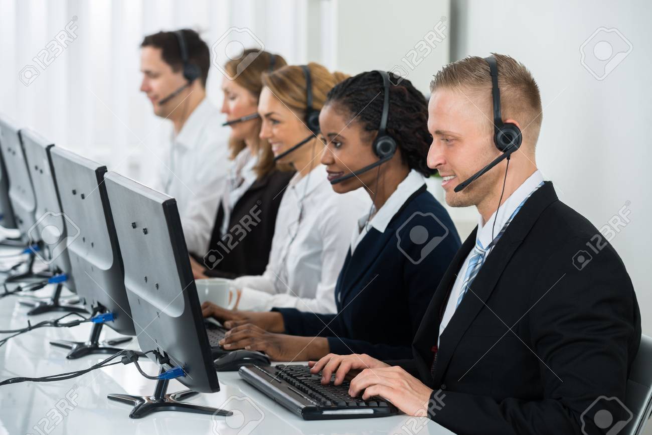 Team Of Businesspeople With Headsets Working In Call Center Office - 57105680 Team Of Businesspeople With Headsets Working In Call Center Office - 57105680