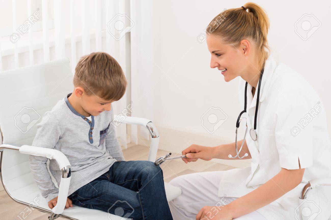 Happy Female Doctor Checking Knee Reflex On A Child Patient In Clinic - 60368644 Happy Female Doctor Checking Knee Reflex On A Child Patient In Clinic - 60368644
