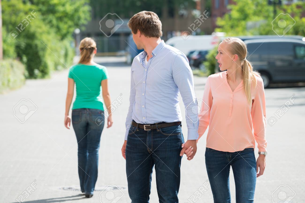 Young Woman Shouting At Her Boyfriend Looking At Another Woman On Street - 60505699 Young Woman Shouting At Her Boyfriend Looking At Another Woman On Street - 60505699
