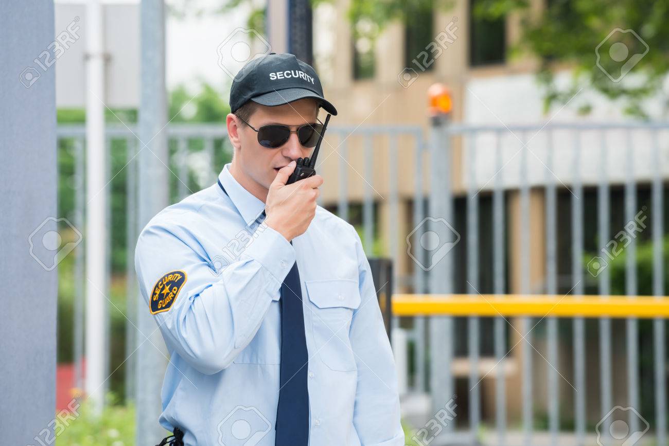 close up of male security guard talking on walkie talkie stock photo security guard