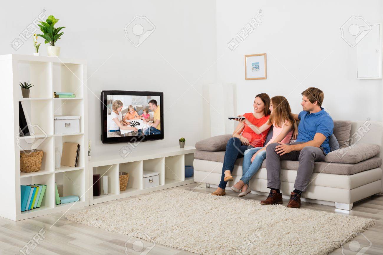 Family Sitting On Sofa Watching Television At Home - 63937482 Family Sitting On Sofa Watching Television At Home - 63937482