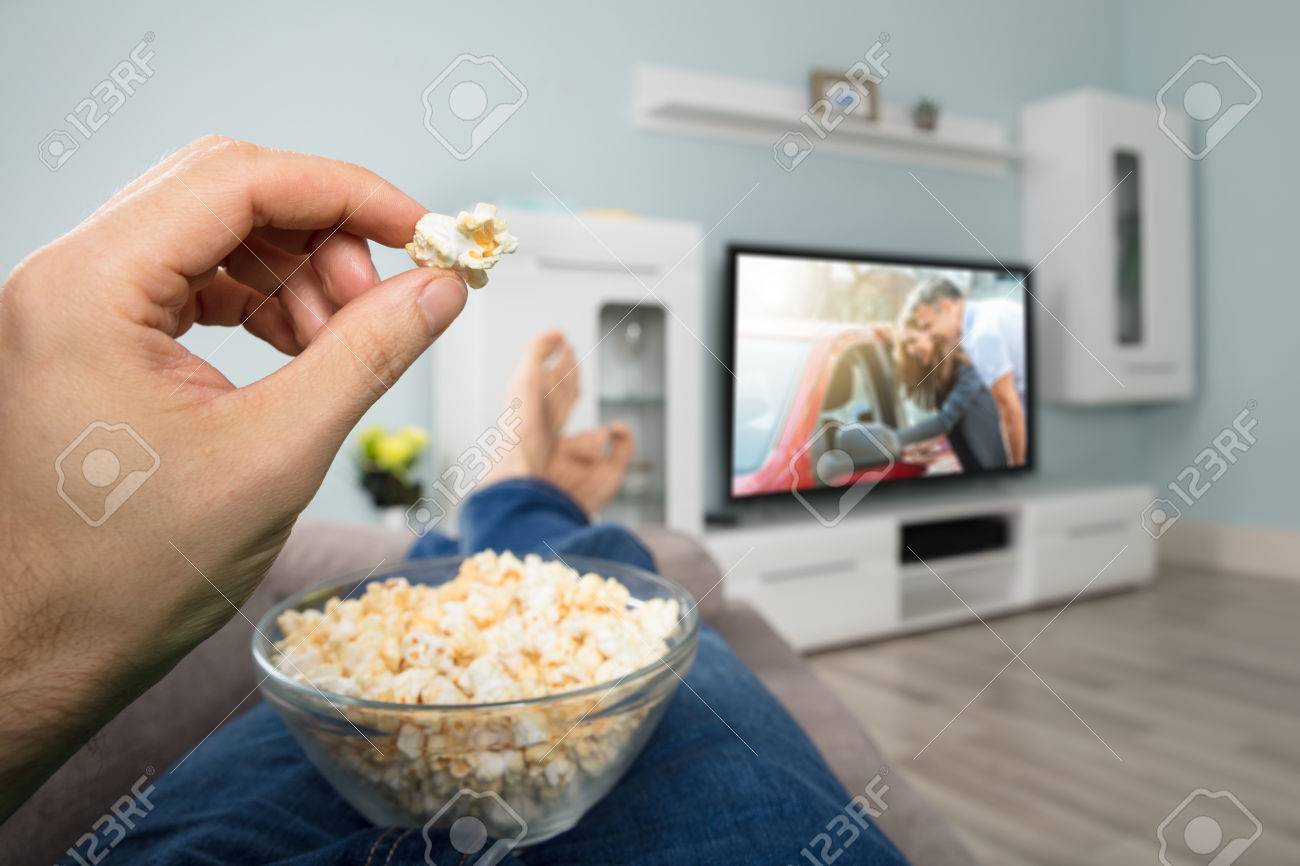 Close Up D Une Personne Profitez De Regarder Un Film Sur La Television En Mangeant Popcorn Banque D Images Et Photos Libres De Droits Image 74217764