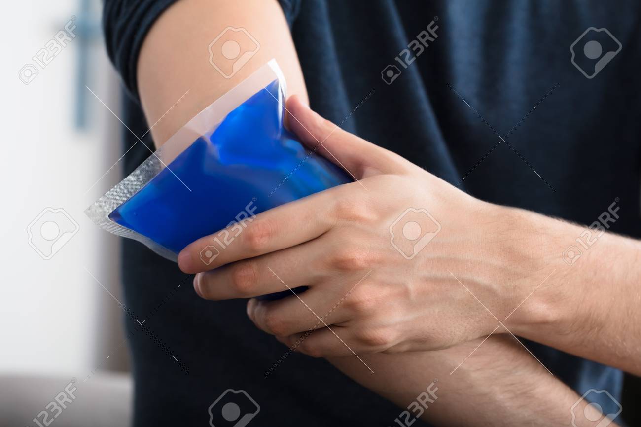 Close-up Of A Person Applying Ice Gel Pack On An Injured Elbow At Home - 87896047 Close-up Of A Person Applying Ice Gel Pack On An Injured Elbow At Home - 87896047