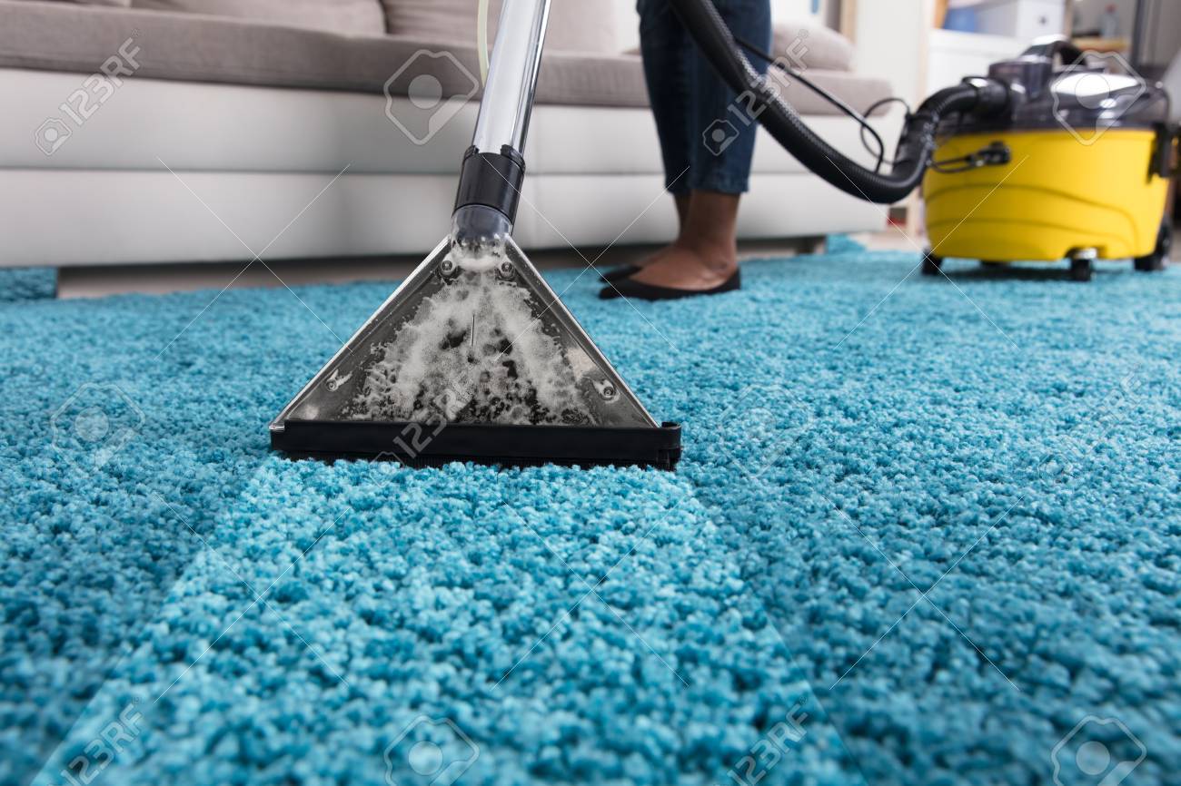 Personne Utilisant Un Aspirateur Pour Nettoyer Le Tapis Bleu À La