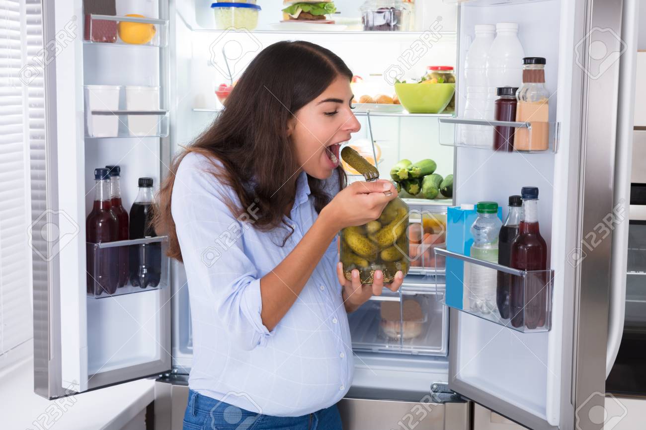 Junge Frau Die Gurken Vom Glas Nahe Kuhlschrank Isst Lizenzfreie Fotos Bilder Und Stock Fotografie Image 92336581