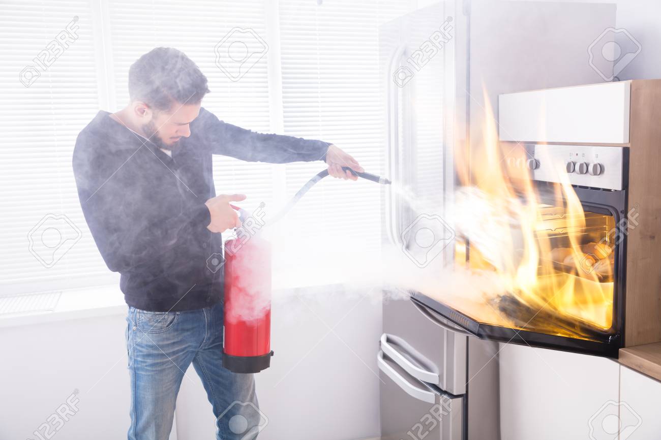 Young Man Using Red Fire Extinguisher To Stop Fire Coming From Stock Photo Picture And Royalty Free Image Image 93523283