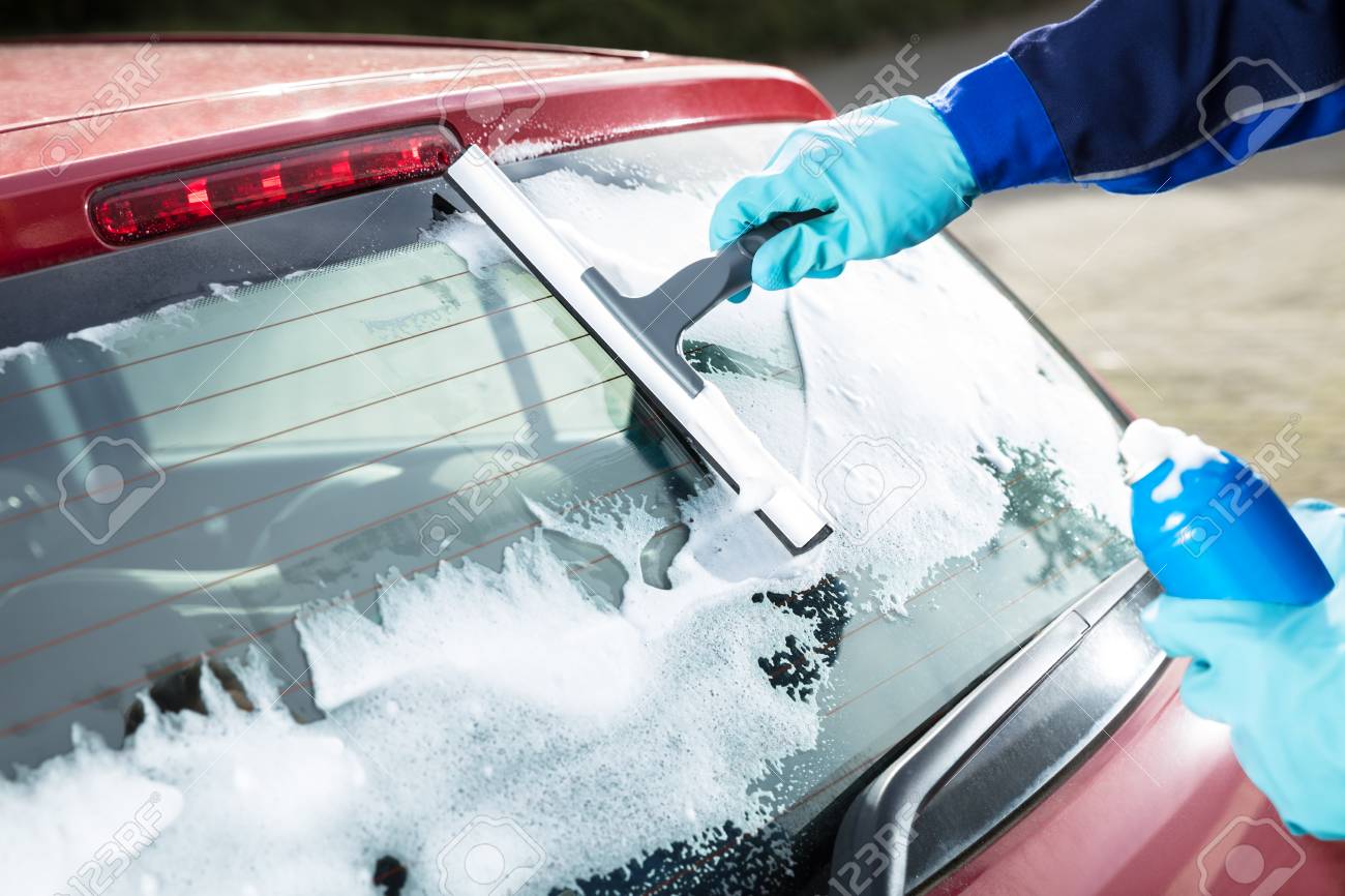 Close-up Of Man's Hand Cleaning The Car Window By Squeegee Stock