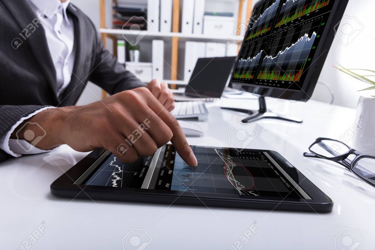 Close-up Of A Businessperson's Hand Working With Graph On Digital Tablet At Workplace - 94989321 Close-up Of A Businessperson's Hand Working With Graph On Digital Tablet At Workplace - 94989321