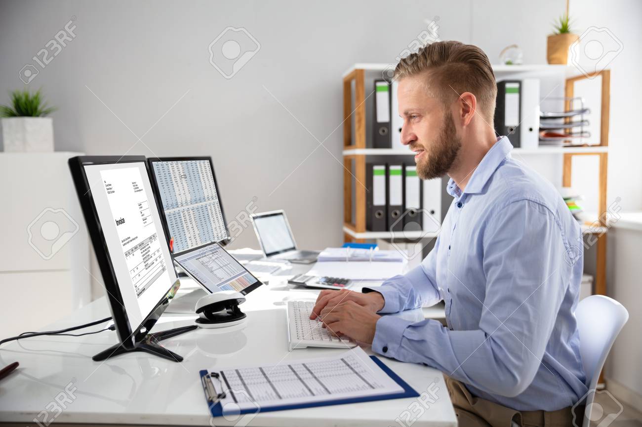 Businessperson Calculating E-Invoice Online On Computer At Office - 121987475 Businessperson Calculating E-Invoice Online On Computer At Office - 121987475