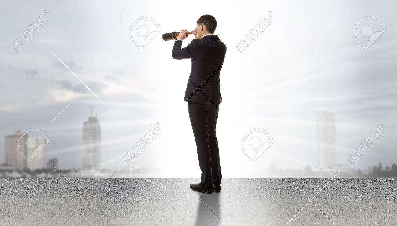 Businessman standing on a on road and looking through a telescope at city - 38886015 Businessman standing on a on road and looking through a telescope at city - 38886015