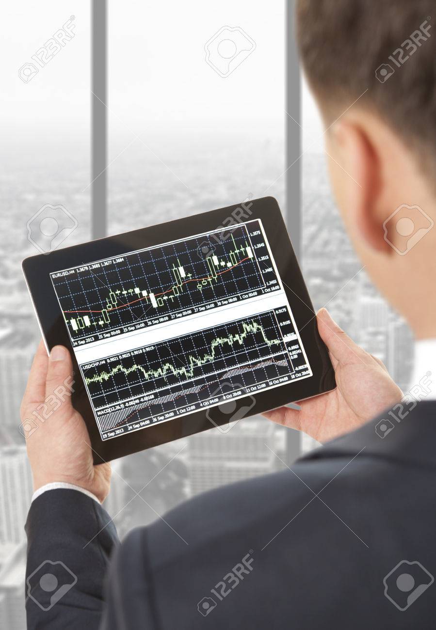 Businessman checking the stock market on digital tablet in office - 39504400 Businessman checking the stock market on digital tablet in office - 39504400