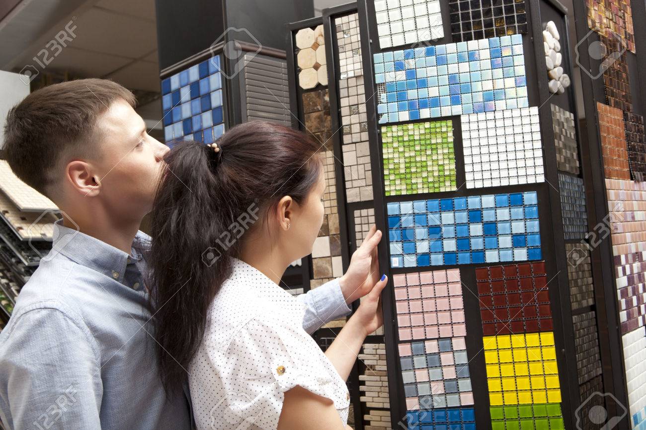Couple pointing at ceramic mosaic tile for bathroom wall in store, in home improvement warehouse exterior - 64184513 Couple pointing at ceramic mosaic tile for bathroom wall in store, in home improvement warehouse exterior - 64184513