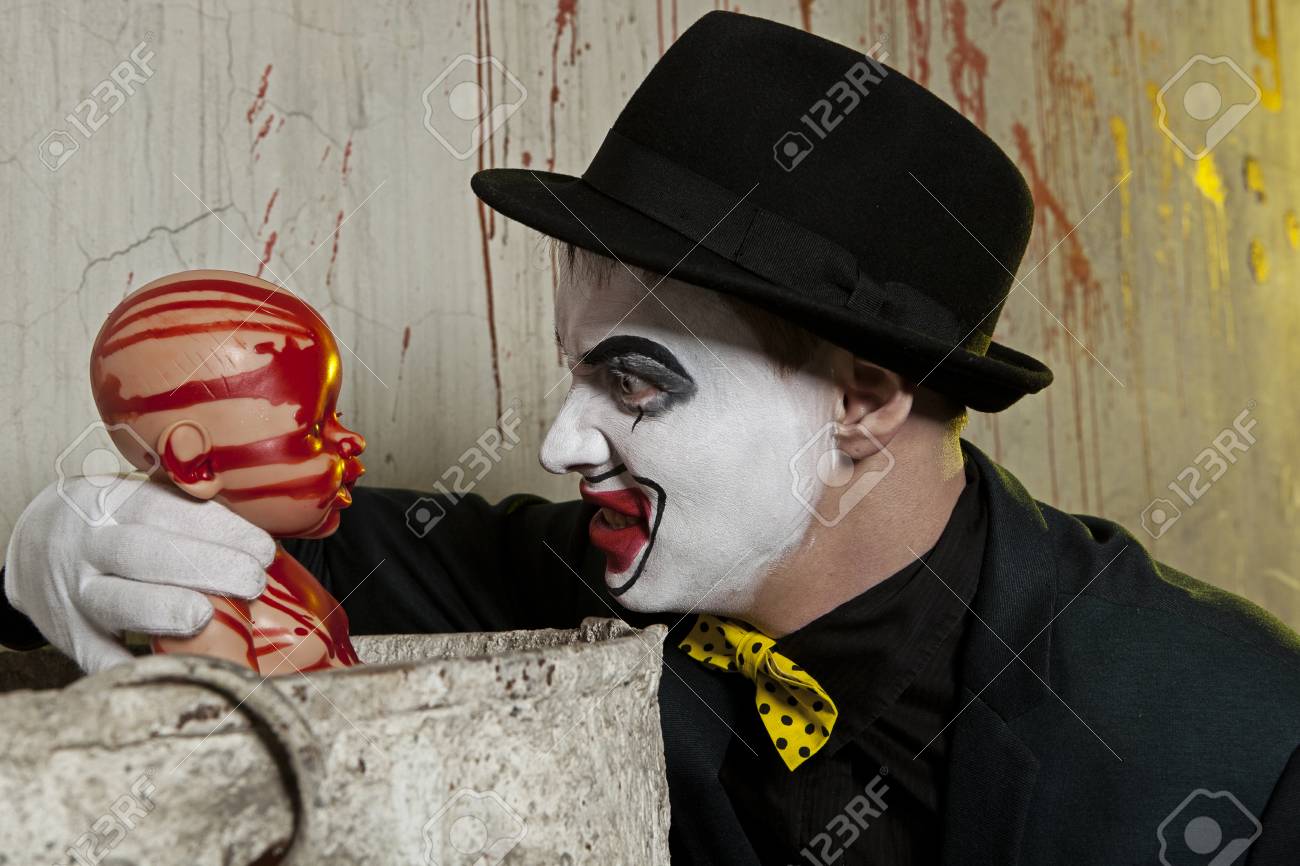 血まみれの人形で遊ぶ怖い邪悪なピエロ の写真素材 画像素材 Image