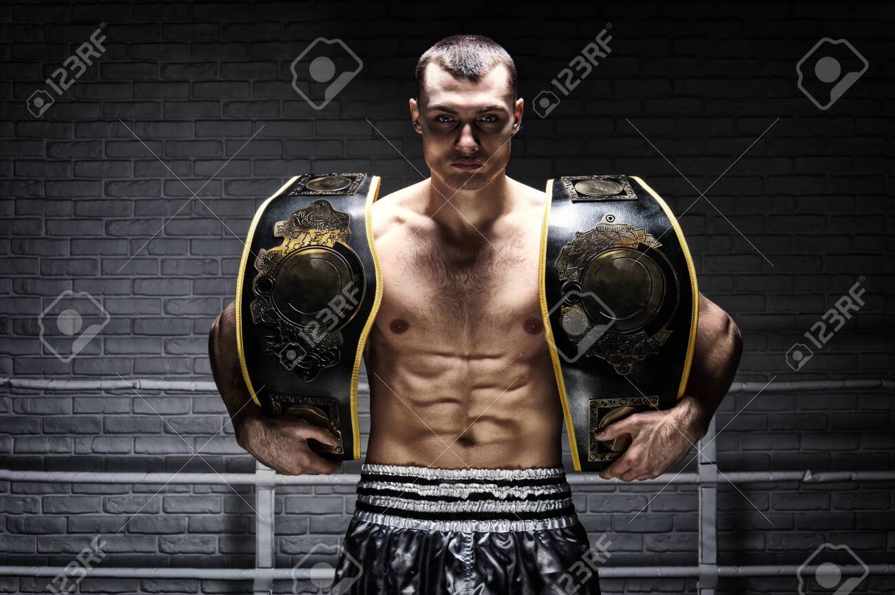 El Campeón Mundial De Peso Mediano De Kickboxing Se Con Dos Cinturones. El Concepto De Un Estilo De Vida Saludable, Victoria, éxito. Motivación. Técnica Mixta Fotos, Retratos, Imágenes Y Fotografía De
