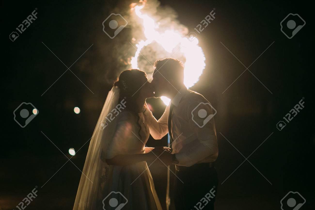 ロマンチックなキスには 燃えるような心の前にカップルだけと結婚しました 夜のショット の写真素材 画像素材 Image