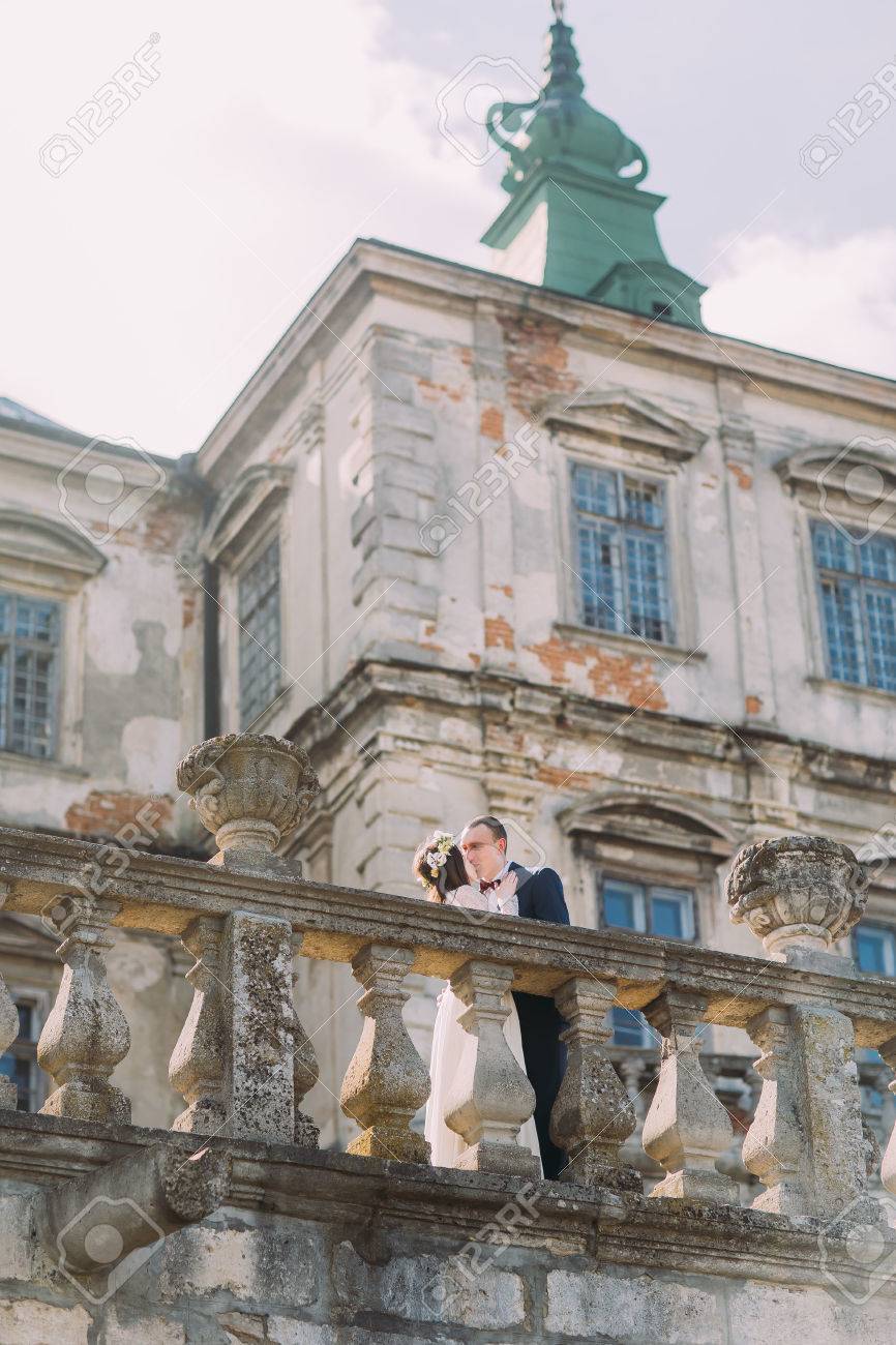 魅力的な新婚新郎新婦のキス美しい廃墟のバロック様式の宮殿の近くの手すりと古いテラスで の写真素材 画像素材 Image