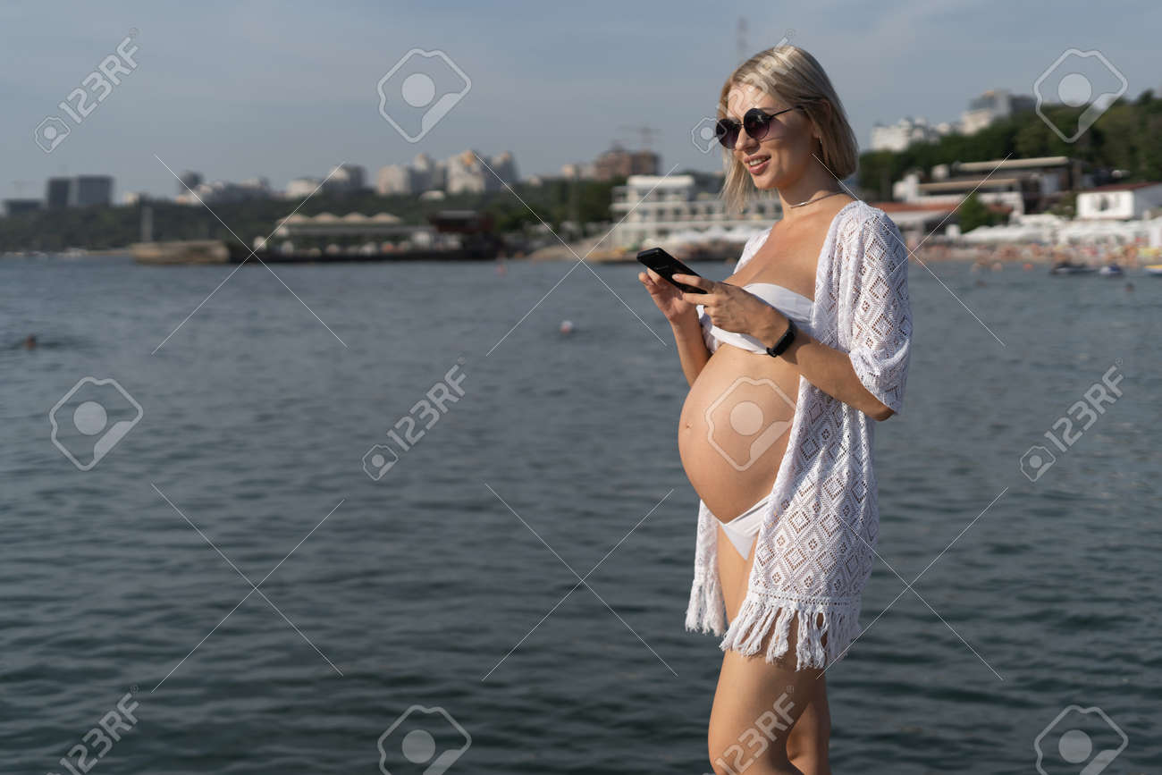 Pregnant Woman By The Ocean Type A Message On The Phone Vacation Stock Photo Picture And Royalty Free Image Image 157996616