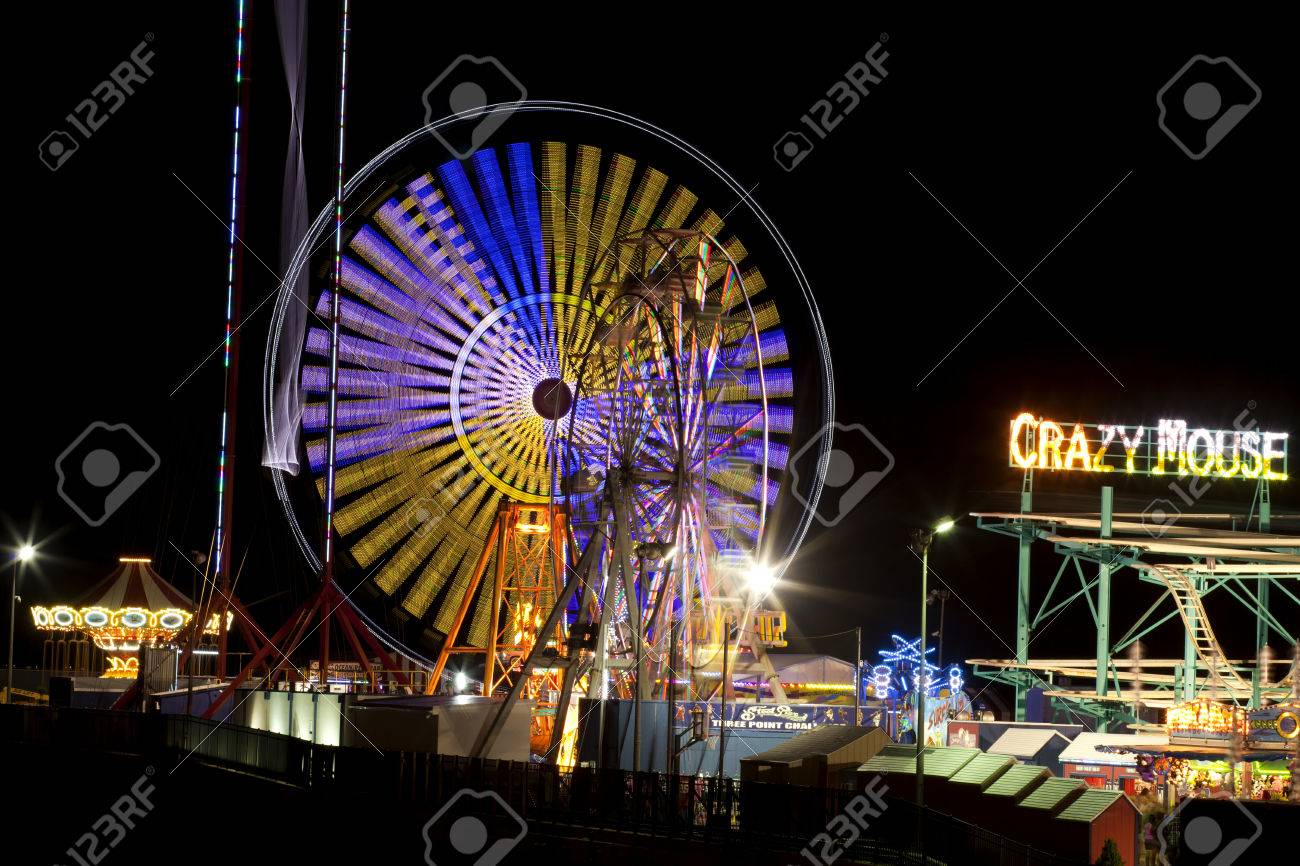 鋼製橋脚娯楽桟橋ビーチおよびアトランティック シティの海に伸びるし トランプ タジマハル カジノ リゾートから遊歩道の向かいです 運動の長時間露光の夜のショットのぼかし効果の乗り物 の写真素材 画像素材 Image