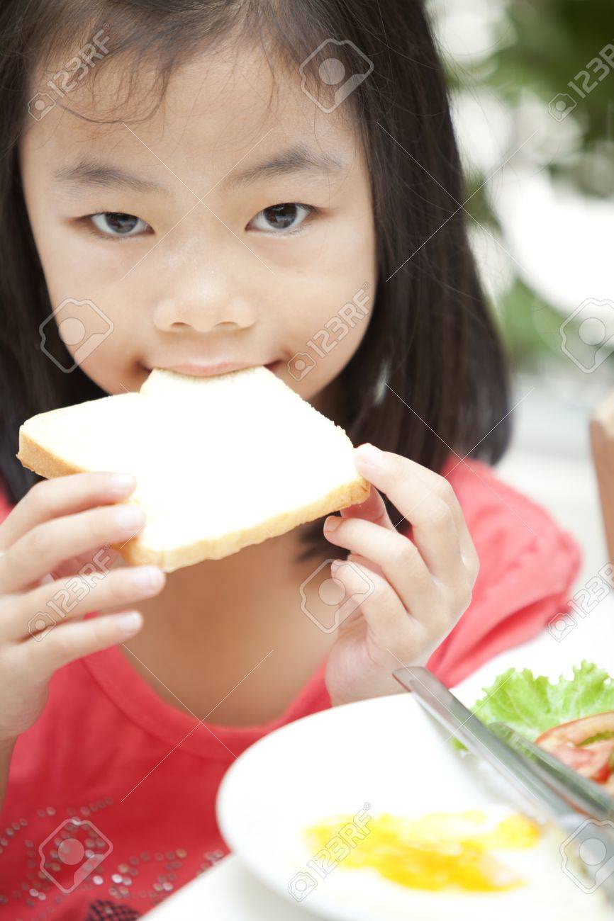 若い可愛い女の子ポニーテール 自然の中でパンを食べると の写真素材 画像素材 Image