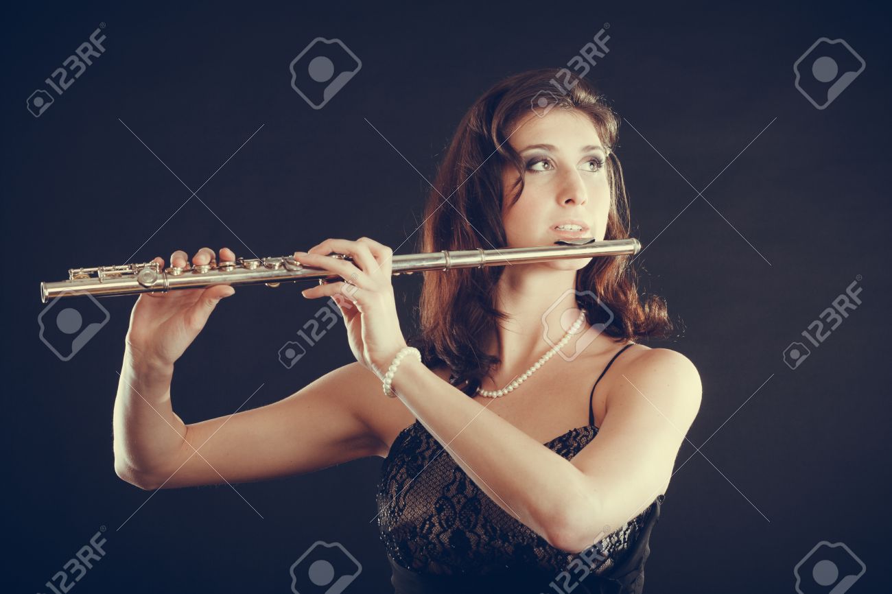 音楽と優雅さ 魅力的なエレガントな女性横笛の演奏します 楽器を実行する彼女の女性ミュージシャン の写真素材 画像素材 Image