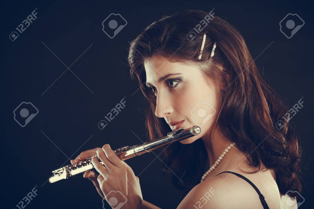 音楽と優雅さ 魅力的なエレガントな女性横笛の演奏します 楽器を実行する彼女の女性ミュージシャン の写真素材 画像素材 Image