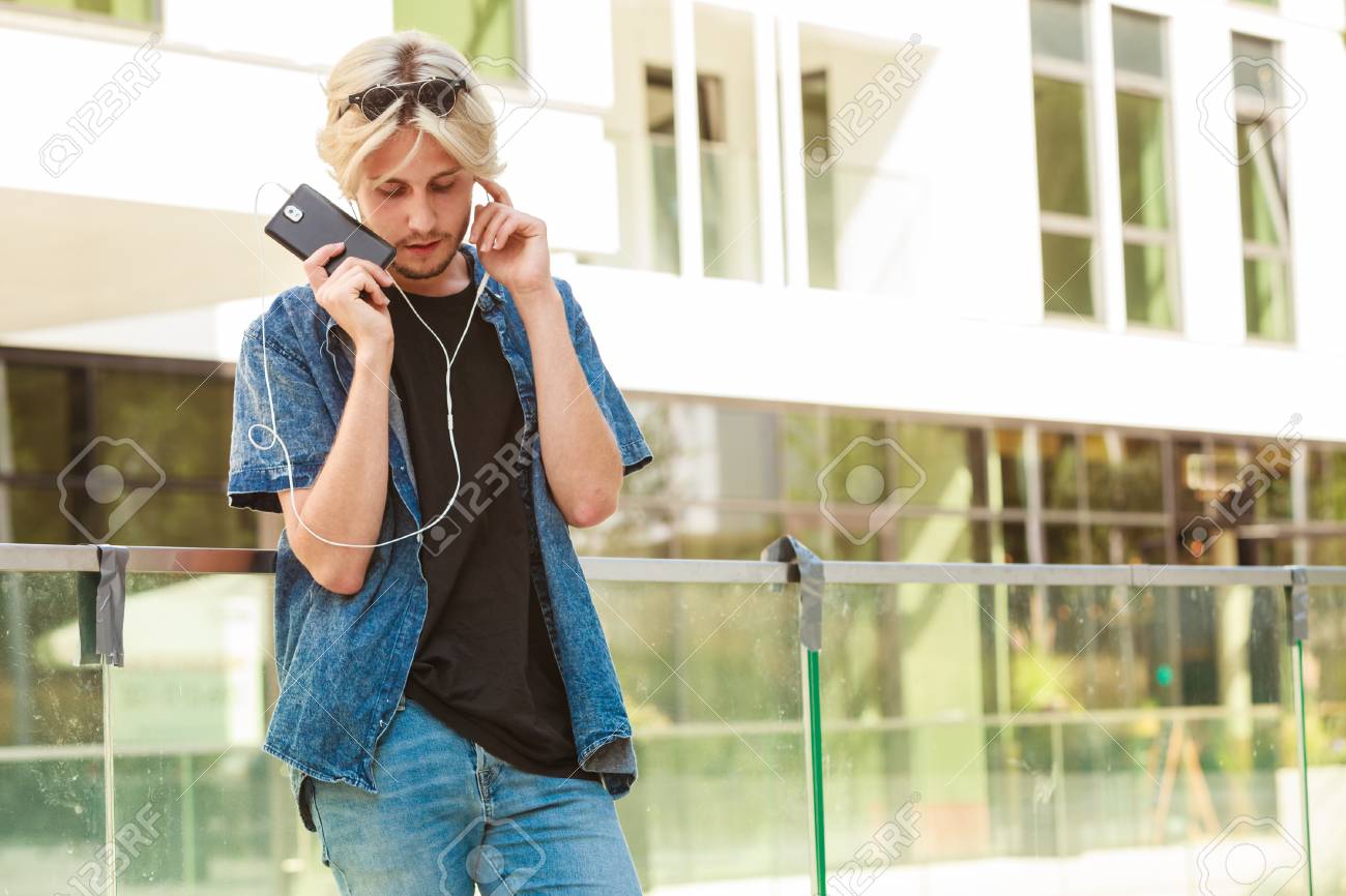 男性ファッション 技術 都会的なスタイルの服のコンセプト 電話で話している都市通り身に着けているジーンズ服イヤホンを介して音楽を聴く上に立っている流行に敏感な男 の写真素材 画像素材 Image 男性ファッション 技術 都会的なスタイルの服のコンセプト 電話で話している都市通り身に着けているジーンズ服イヤホンを介して音楽を聴く上に立っている流行に敏感な男 の写真素材 画像素材 Image