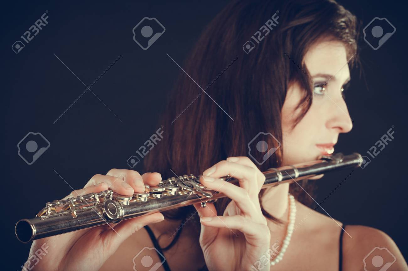 音楽と優雅さ 魅力的なエレガントな女性横笛の演奏します 楽器を実行する彼女の女性ミュージシャン の写真素材 画像素材 Image