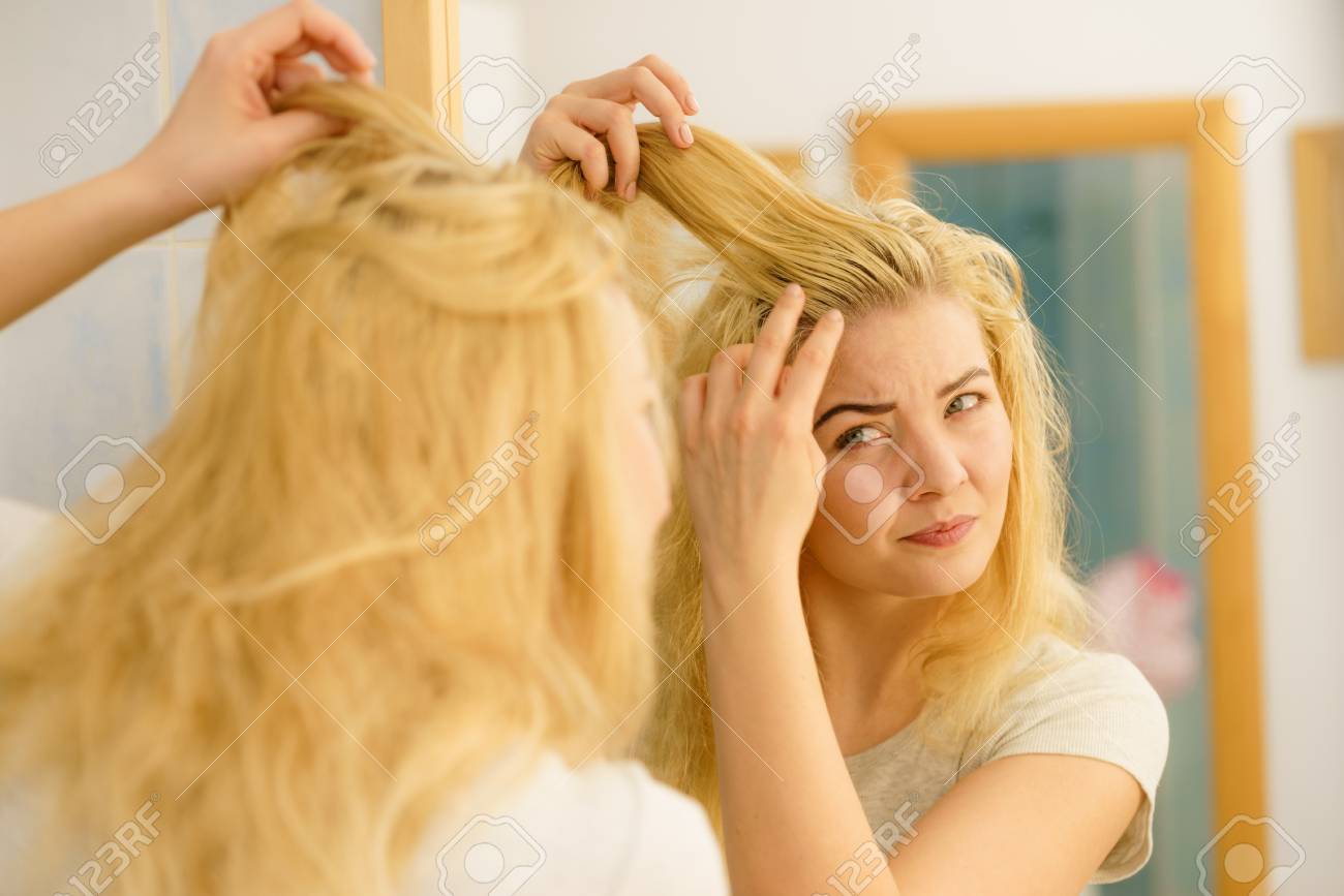 Blonde Woman Having Problems With Greasy Oily Hair Looking At