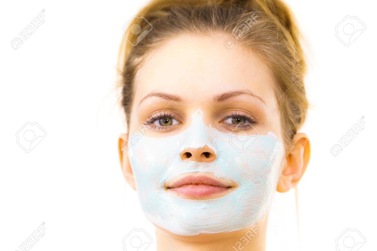 Young woman applying green mud mask to face, on white. Teen girl taking care of oily skin, purifying the pores. Beauty treatment. Skincare. - 121855357 Young woman applying green mud mask to face, on white. Teen girl taking care of oily skin, purifying the pores. Beauty treatment. Skincare. - 121855357