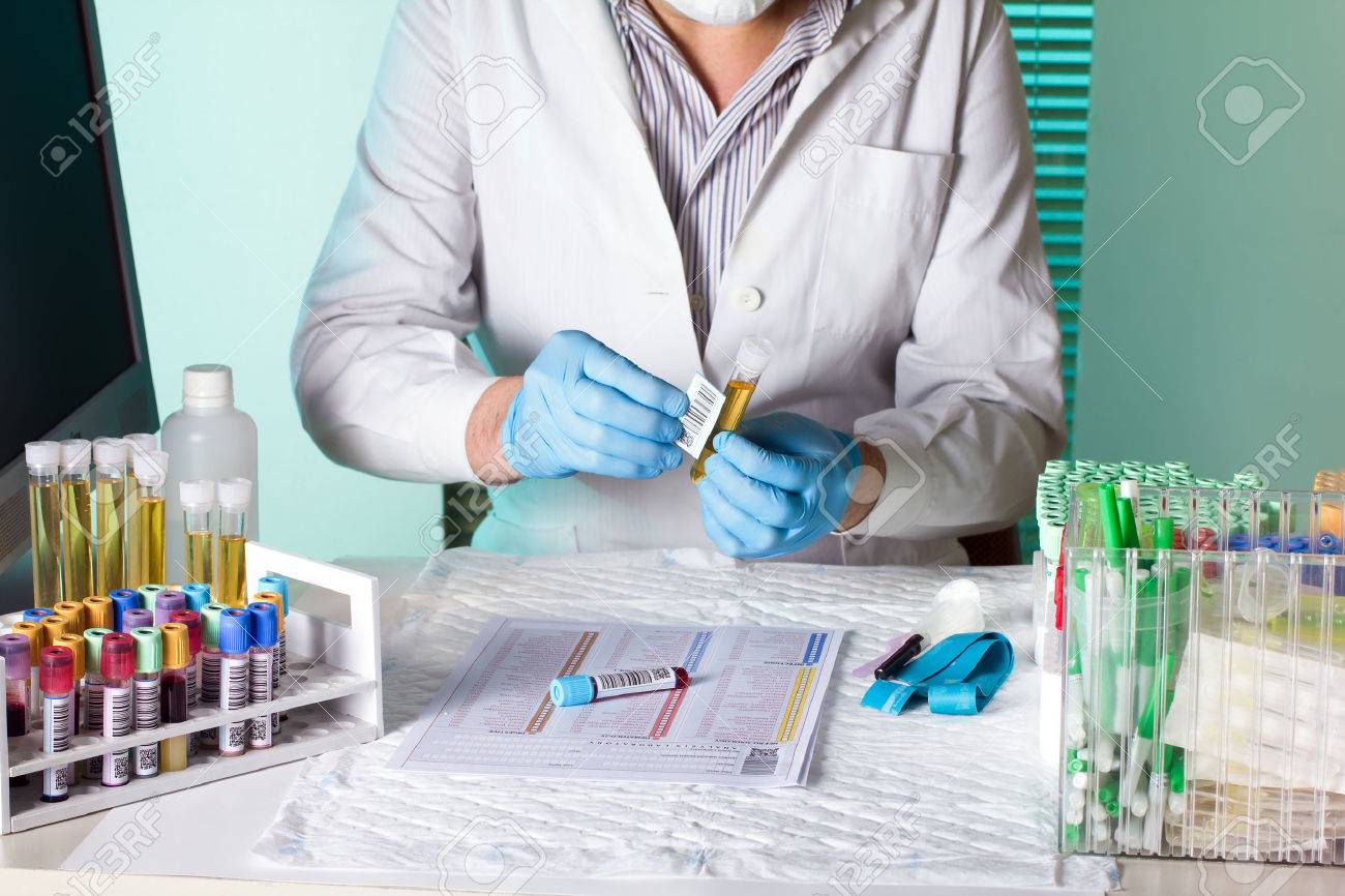 laboratory technician holding and labeling sample tubes urine and blood for coding traceability - 27332688 laboratory technician holding and labeling sample tubes urine and blood for coding traceability - 27332688