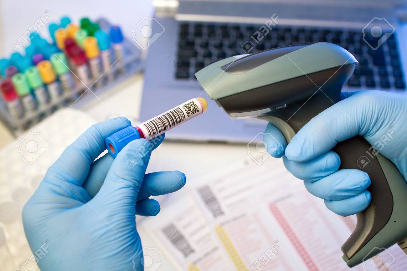 technician hands scanning barcodes on biological sample tube in the lab of blood bank - 29033655 technician hands scanning barcodes on biological sample tube in the lab of blood bank - 29033655