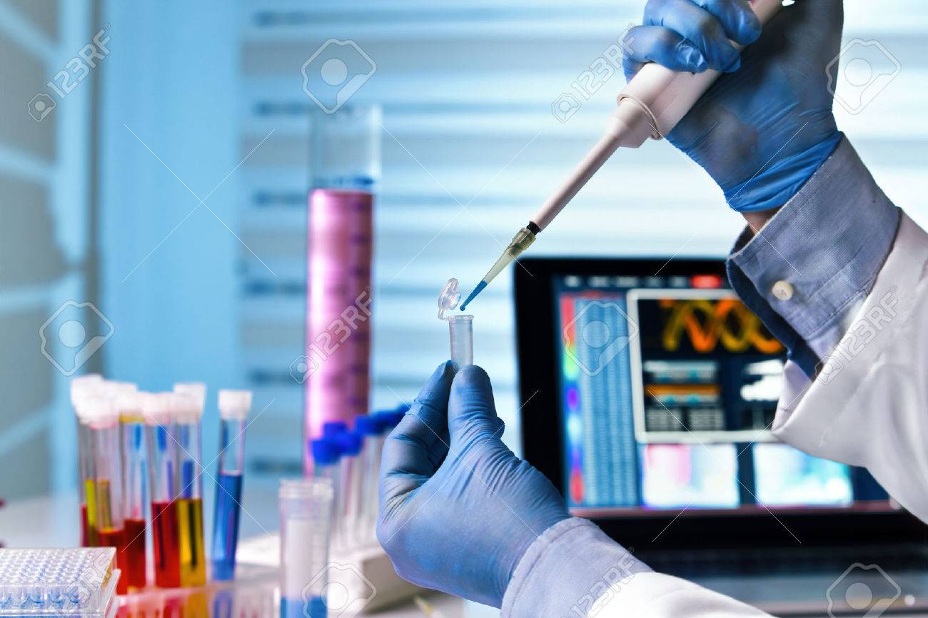 scientist holding tube and working with laptop at genetic lab / hands of engineer genetic working in laboratory - 66097525 scientist holding tube and working with laptop at genetic lab / hands of engineer genetic working in laboratory - 66097525