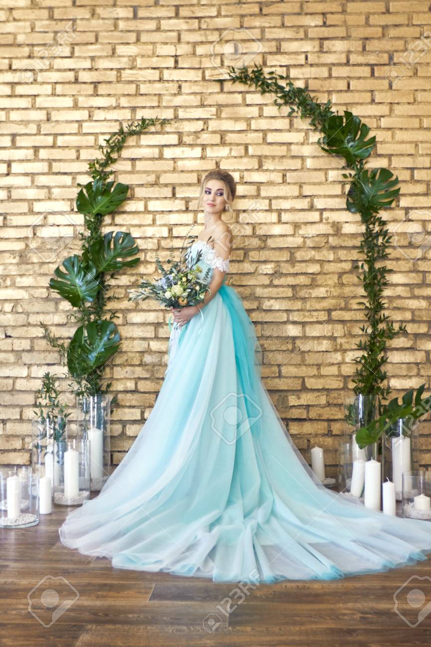 花嫁が結婚式を見越して美しいターコイズ ブルーのドレス 花束を持つレース ドレス海緑のブロンド 幸せな花嫁 感情 彼の顔に喜び 美しい化粧 マニキュア ヘアスタイル女性 の写真素材 画像素材 Image