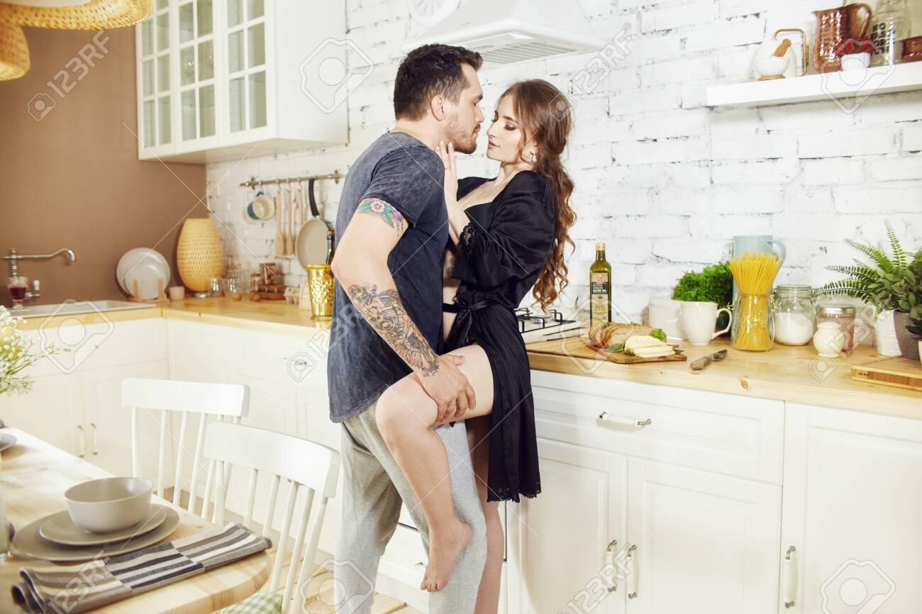 Couple In Love In The Kitchen In The Morning Hugs And Prepares Stock Photo Picture And Royalty Free Image Image 128993346