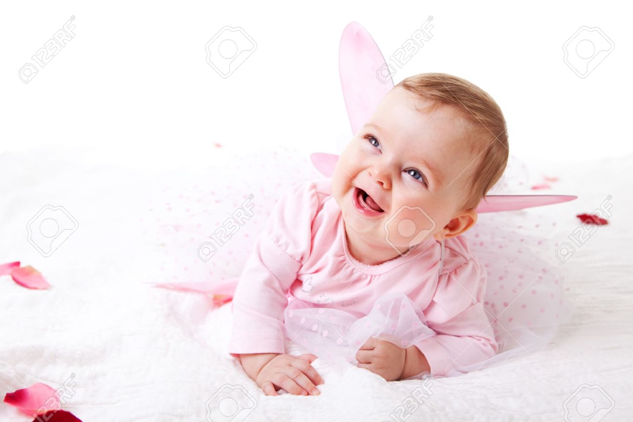 A Cute Baby Girl In Fairy Wings Laughs While Lying On The Ground Stock Photo Picture And Royalty Free Image Image 7157239