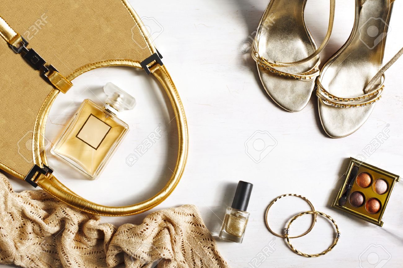 Women's set of fashion accessories in golden color on wooden background: shoes, handbag, perfume and cosmetics - 55136602 Women's set of fashion accessories in golden color on wooden background: shoes, handbag, perfume and cosmetics - 55136602