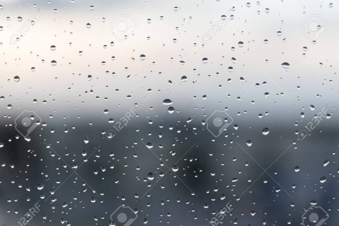 暗い雨の日に濡れている窓ガラスに雨粒します 背景が完全にぼやけています の写真素材 画像素材 Image