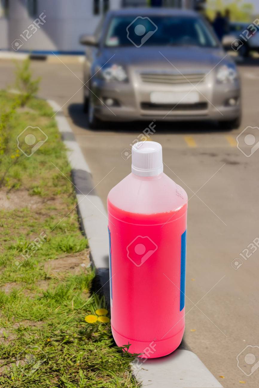 自動車エンジンの冷却システムの背景に不凍剤とペットボトルは バック プレーン上の車をぼやけています の写真素材 画像素材 Image