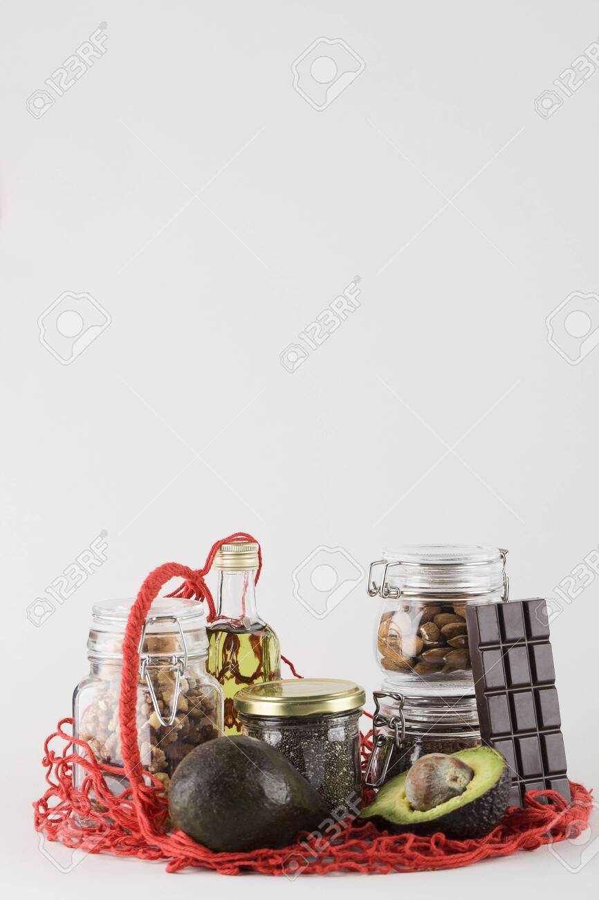 healthy fats sources flax nuts oil avocado chia seeds and bitter chocolate in red mesh bag .healthy food eco friendly concept, copy space - 149021531 healthy fats sources flax nuts oil avocado chia seeds and bitter chocolate in red mesh bag .healthy food eco friendly concept, copy space - 149021531