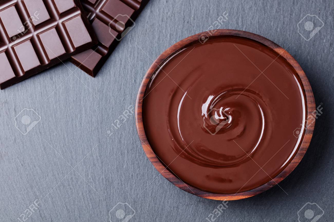 Melted chocolate and bar chocolate. Slate background. Copy space Top view. - 77472441 Melted chocolate and bar chocolate. Slate background. Copy space Top view. - 77472441