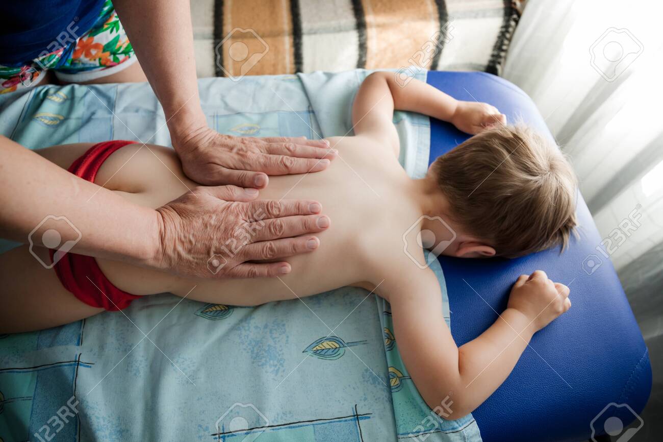 child massage Doctor Osteopath Massage Therapist Is Doing Massage To A Little Boy. Hands  Massage The Back And Cervical-collar Zone. Close-up View Without Face. Mom  Gives Her Baby A Massage. Stock Photo, Picture and