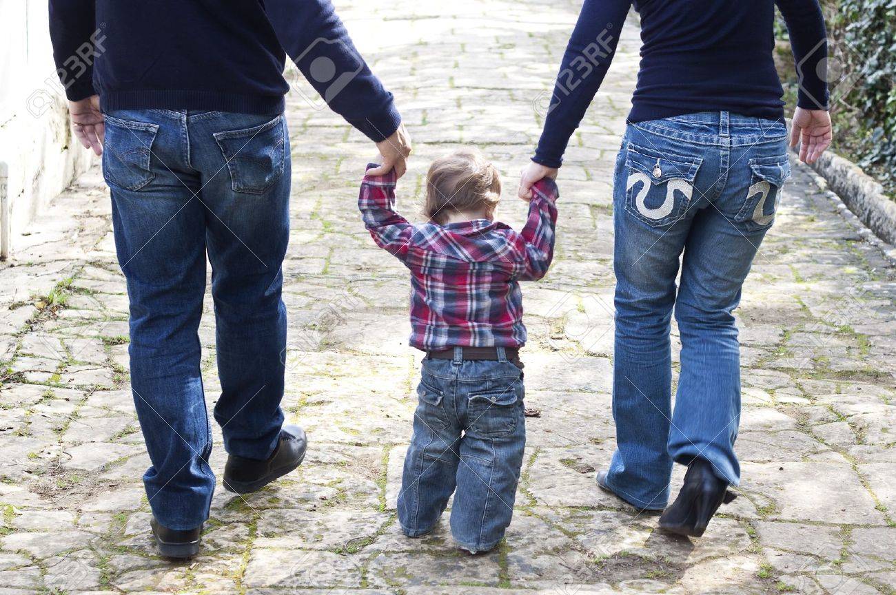 Madre Y Padre Caminando Con Su Hijo Bebe Entre Ellos En Un Parque Fotos Retratos Imagenes Y Fotografia De Archivo Libres De Derecho Image