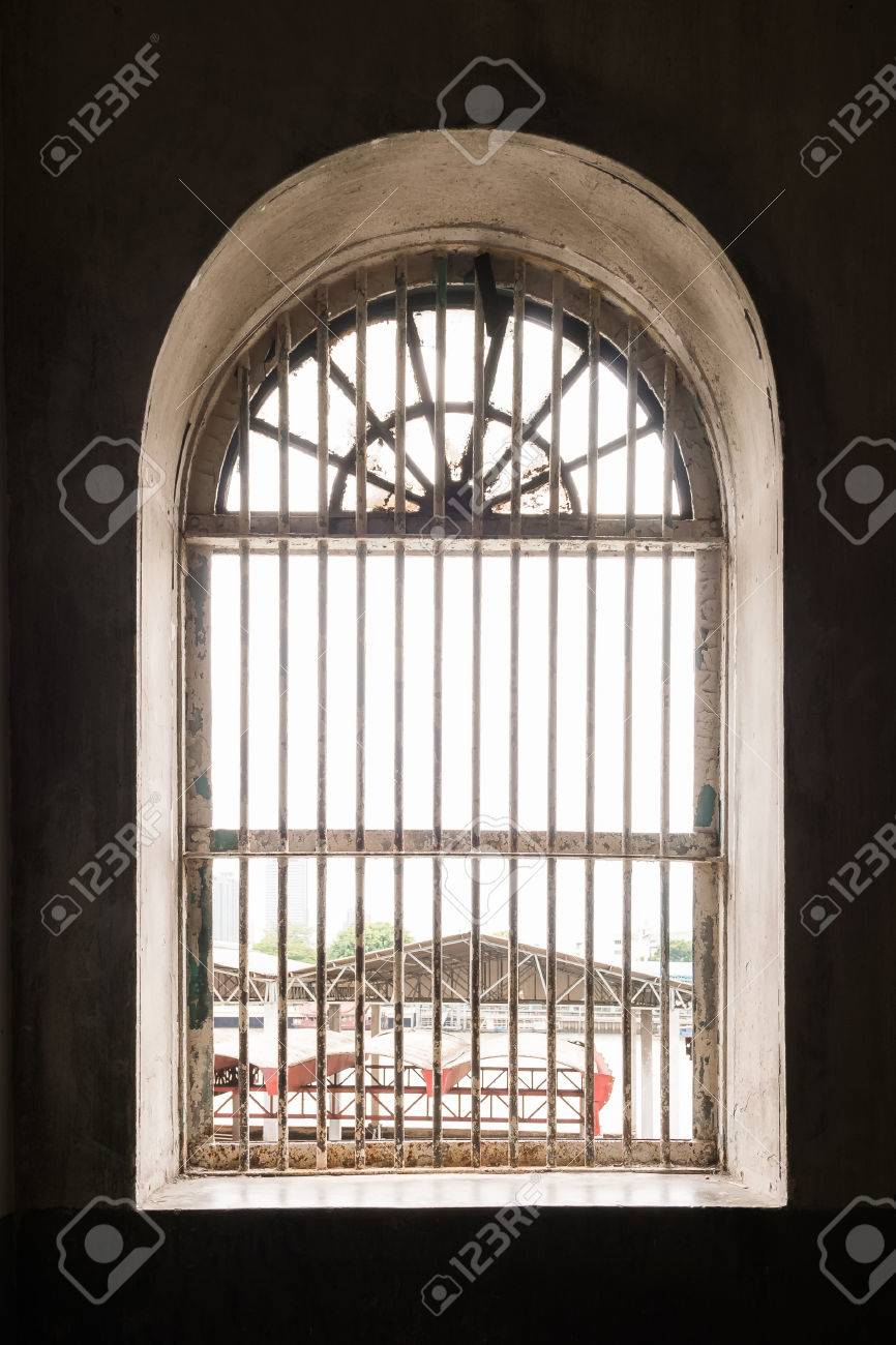 old metal lattice window in the wall of old building stock photo