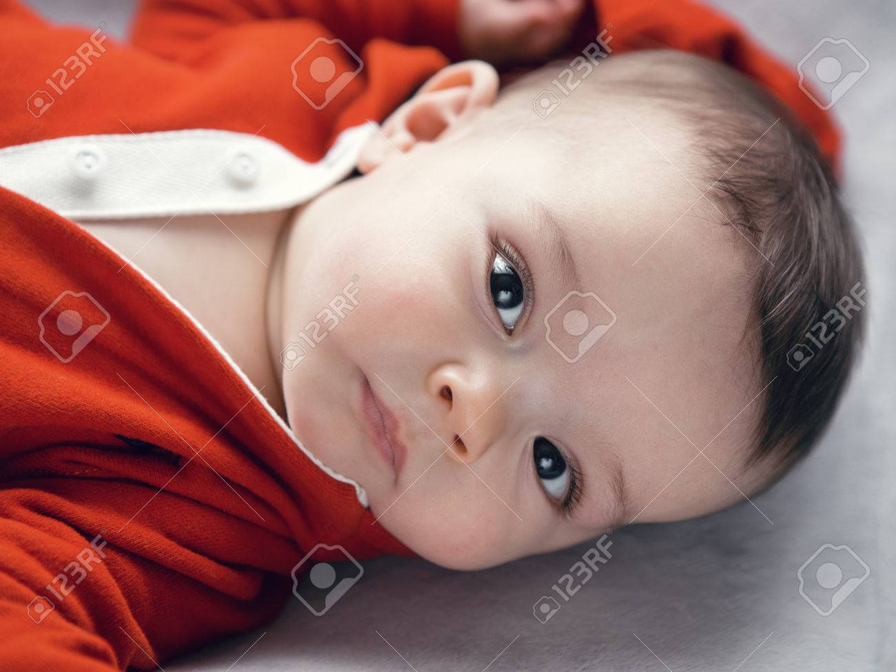 Portrait Gros Plan Mignon Adorable Fille De Race Blanche Bebe Garcon Avec Des Yeux Bruns Noirs De Hoodie De Chemise Rouge Sur Une Table A Langer Regardant Directement Dans L Appareil Photo La