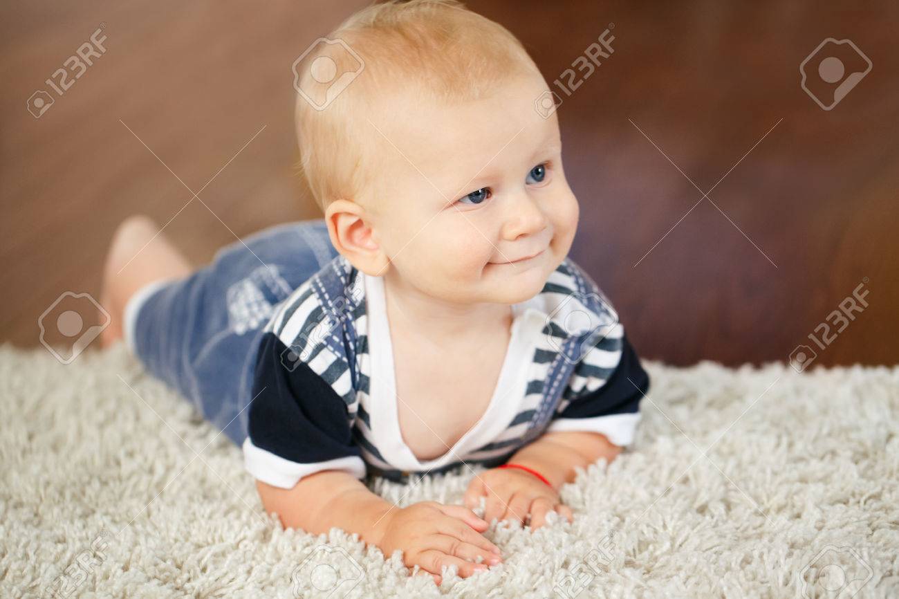 Portrait De Mignon Adorable Blond Caucasien Sourire Bebe Garcon A Yeux Bleus Mensonge Sur Plancher Dans Enfants Chambre Enfants Regarder Loin Banque D Images Et Photos Libres De Droits Image