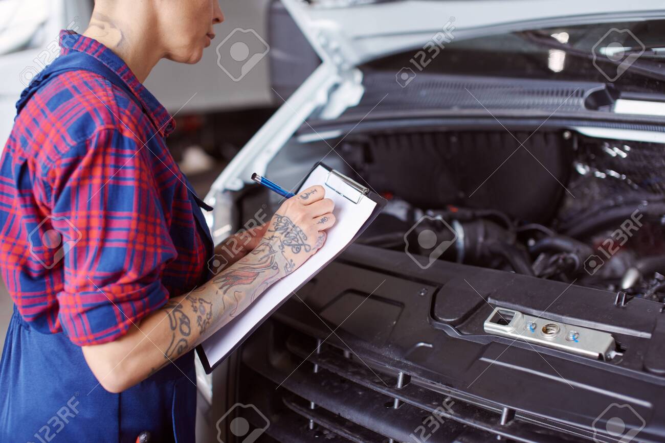 Automechanic makes a list of problems needed to be checked. - 128911951 Automechanic makes a list of problems needed to be checked. - 128911951
