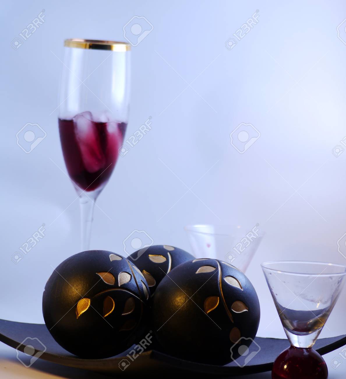 A Glass Of Red Wine With Decor Set Of Wooden Balls