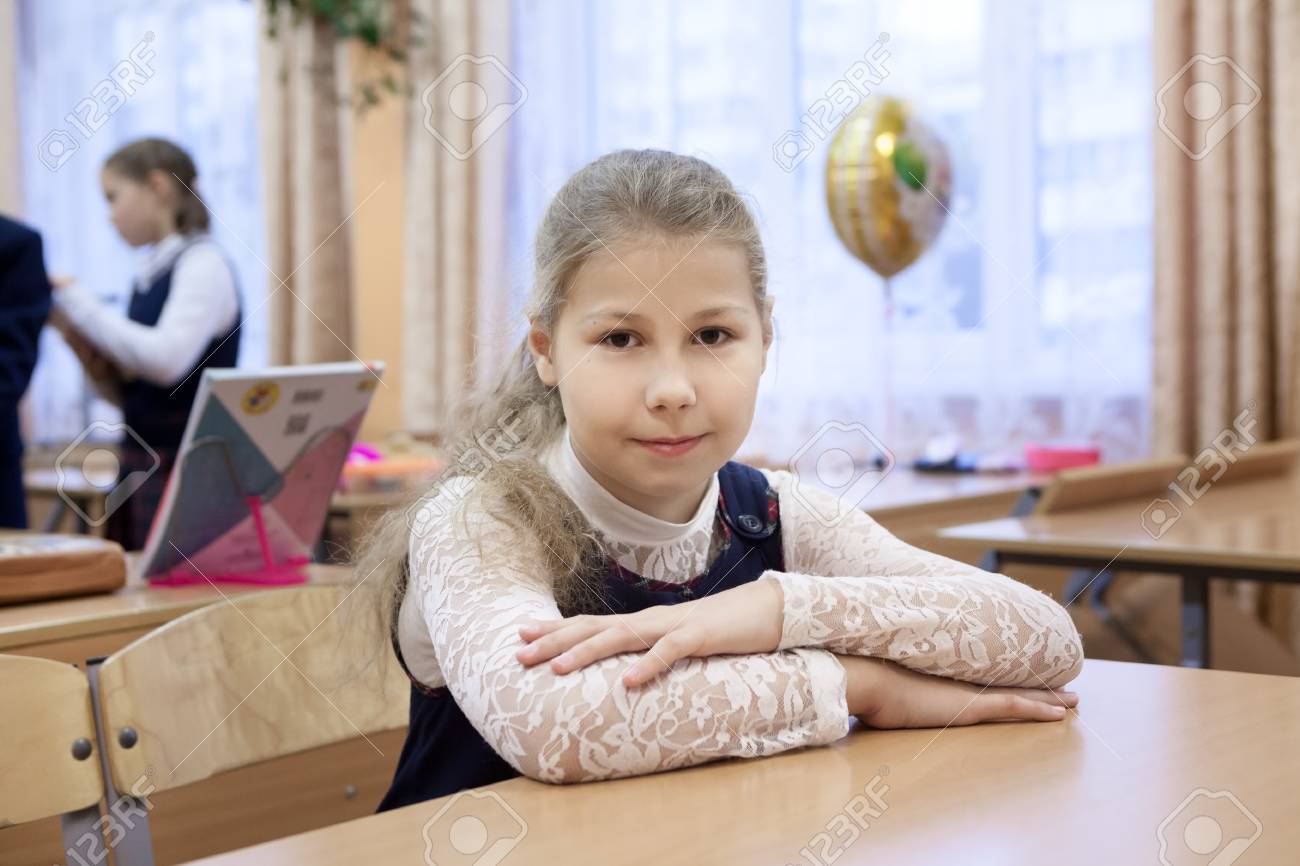 白人女子高生教室とカメラ目線で机に座っての肖像画 の写真素材 画像素材 Image