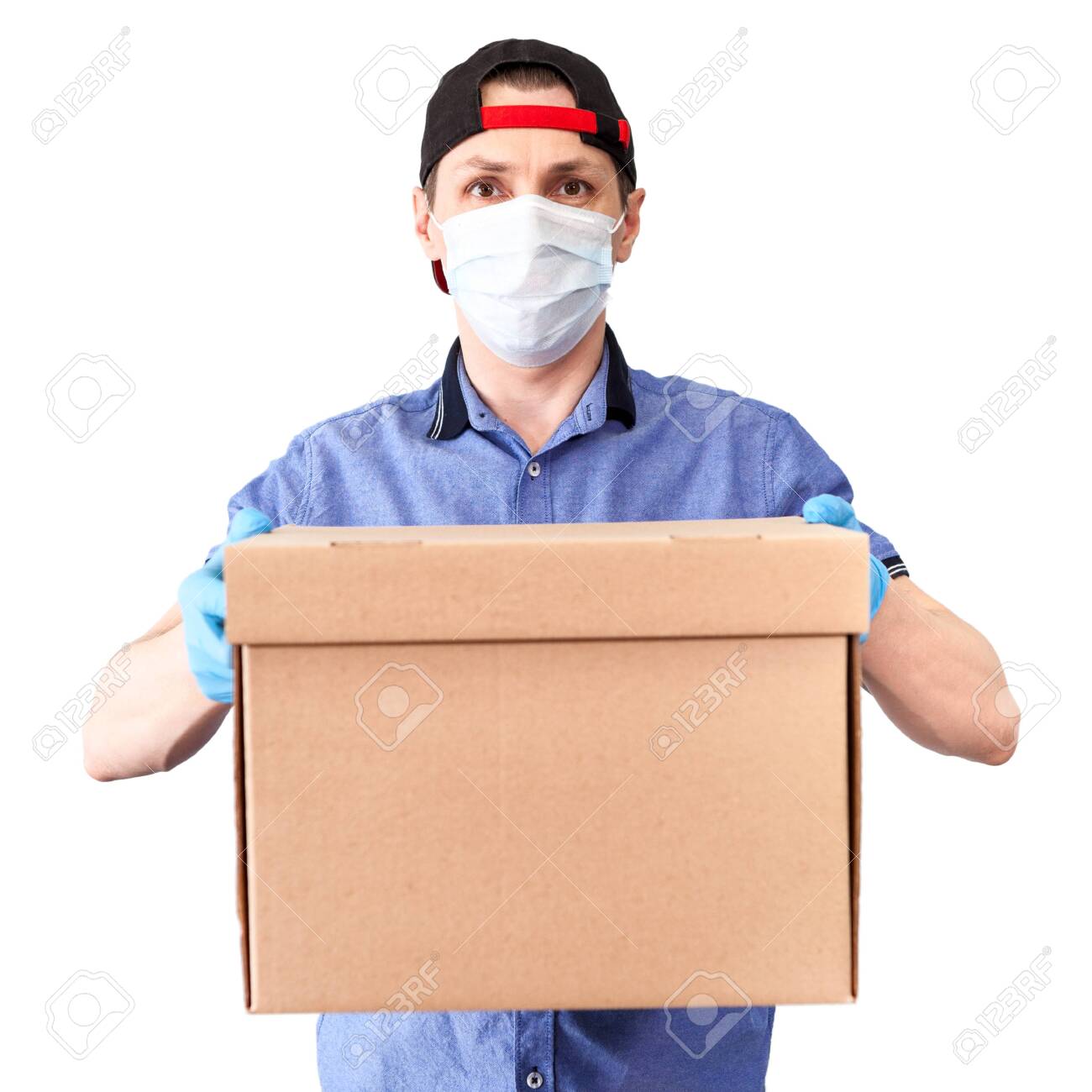 Caucasian delivery man wearing medical mask and blue surgical gloves brings cardboard, isolated on white background - 146344912 Caucasian delivery man wearing medical mask and blue surgical gloves brings cardboard, isolated on white background - 146344912