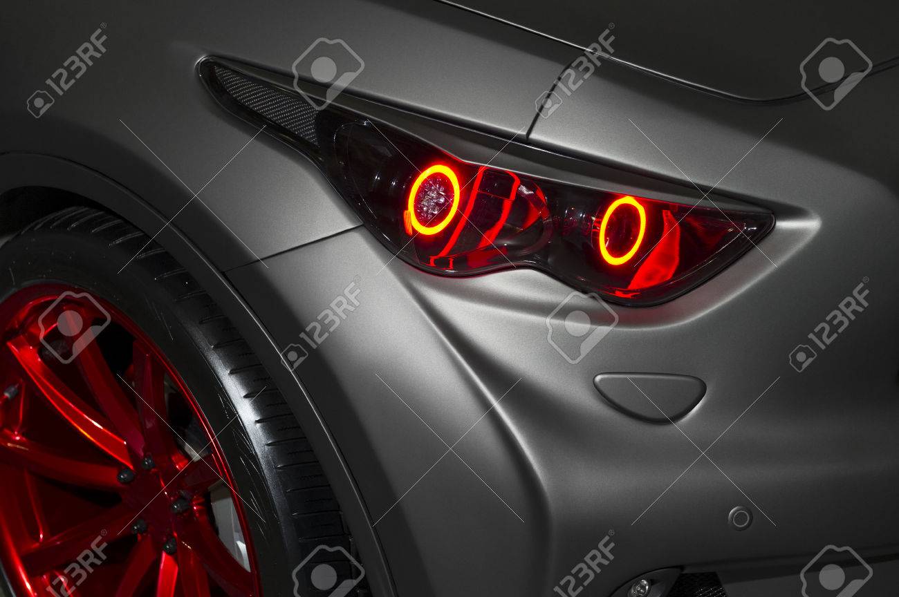 predatory car headlight with red lights and hood of powerful stock